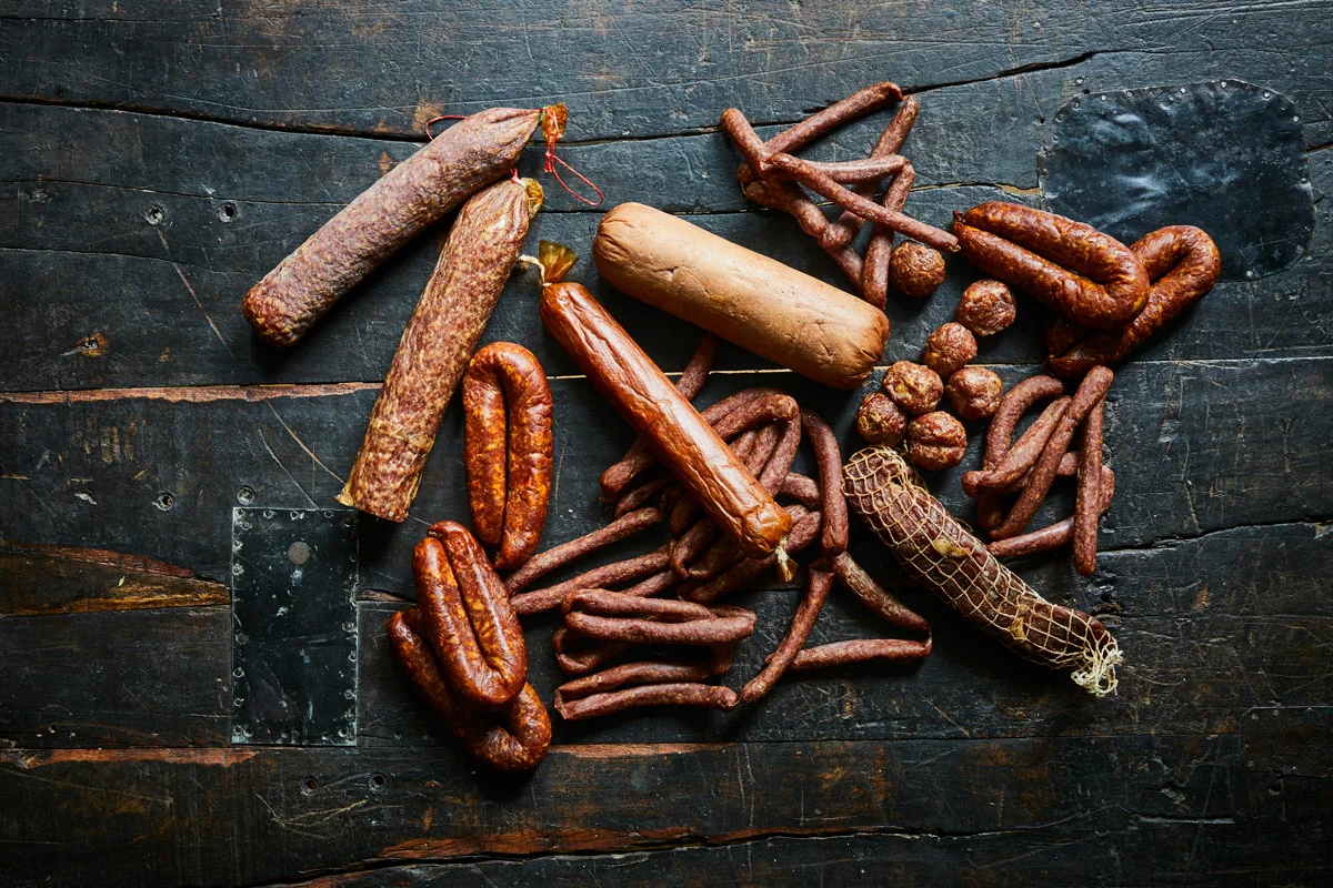 Verschiedene geräucherte Würste auf dunklem Tisch