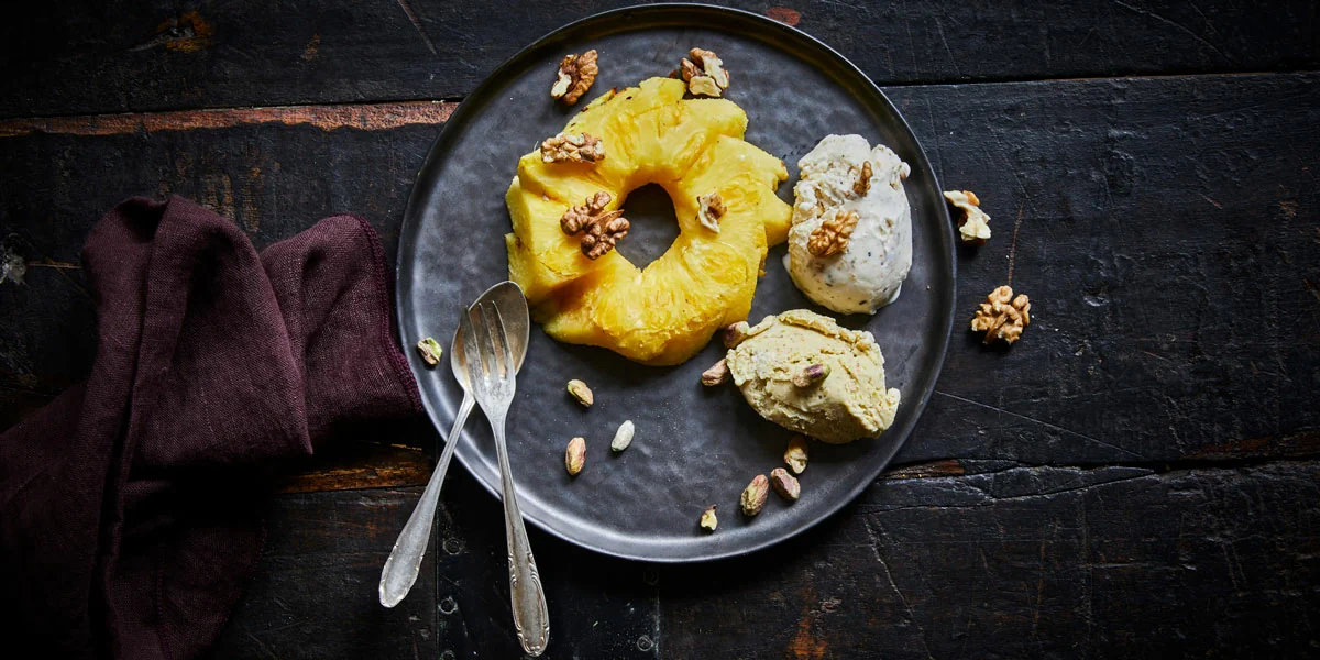 Geräucherte Ananas mit Eis und Nüssen serviert